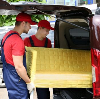 Günstig umziehen in Ratingen Günstig umziehen in Ratingen: Umzugshelfer laden ein gelbes Sofa in einen Transporter