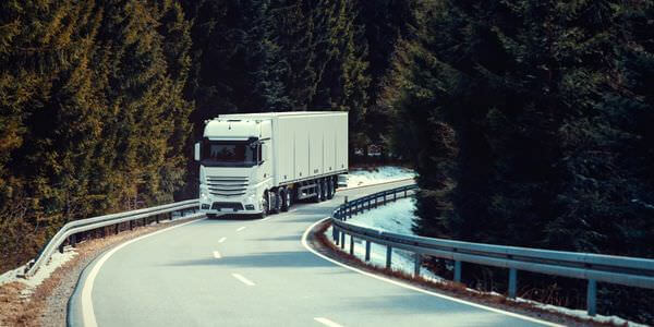 Klaviertransport Ratingen: Lkw fährt auf einer kurvigen Straße durch den Wald